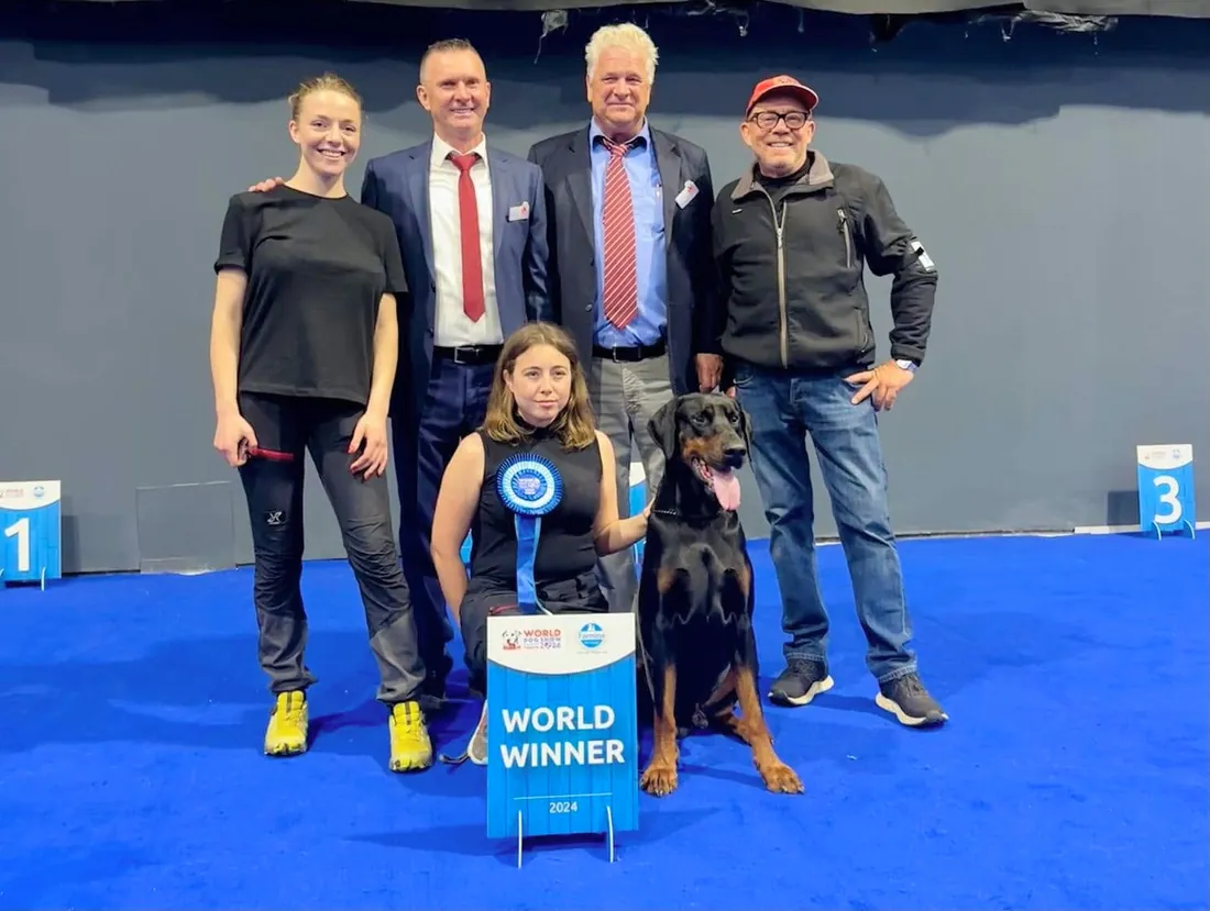 Al World Dog Show 2024 la squadra di Prisconte posa col Dobermann premiato e il cartello World Winner 2024